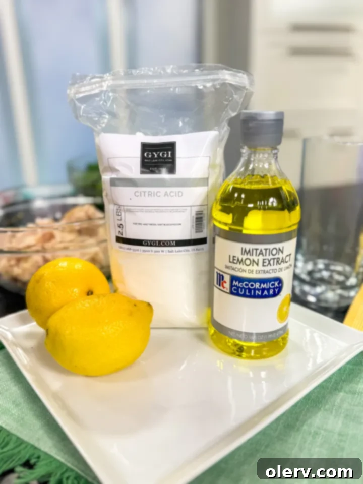 Refreshing Homemade Lemon Water 4 A flat lay of the key ingredients for the lemon water recipe: whole lemons, granulated sugar, citric acid, and lemon extract.