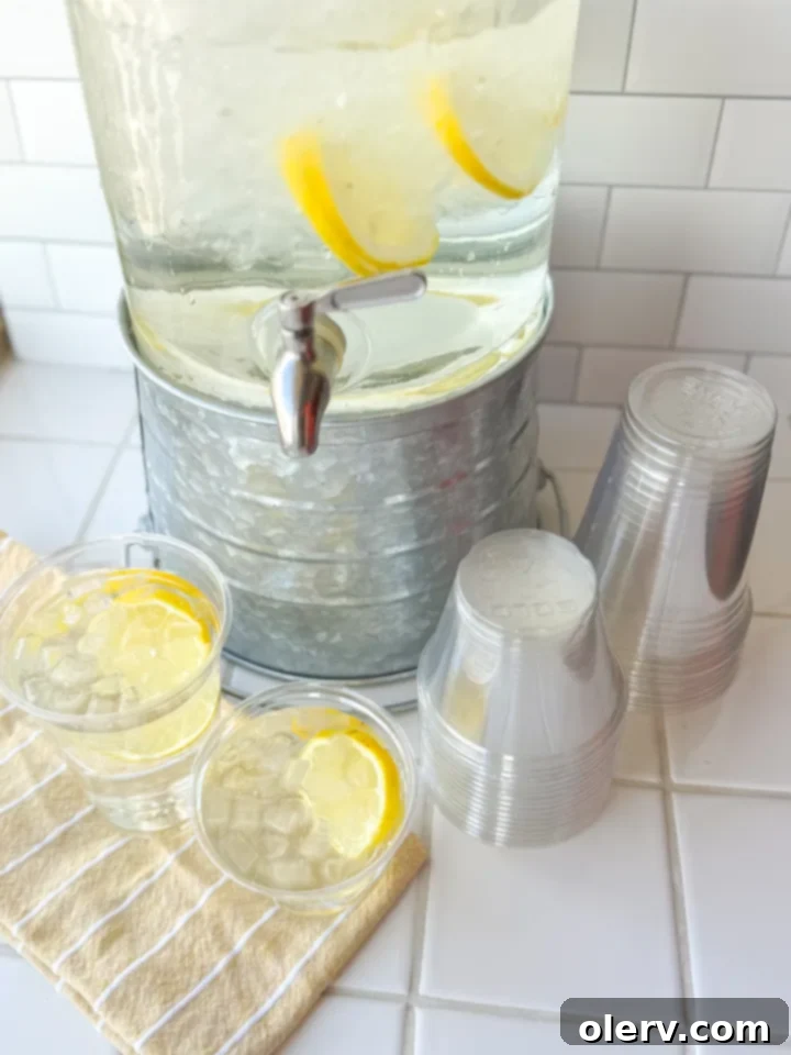Refreshing Homemade Lemon Water 6 A small bowl of white citric acid powder with a spoon, next to a pile of fresh lemons and a bottle of lemon extract.