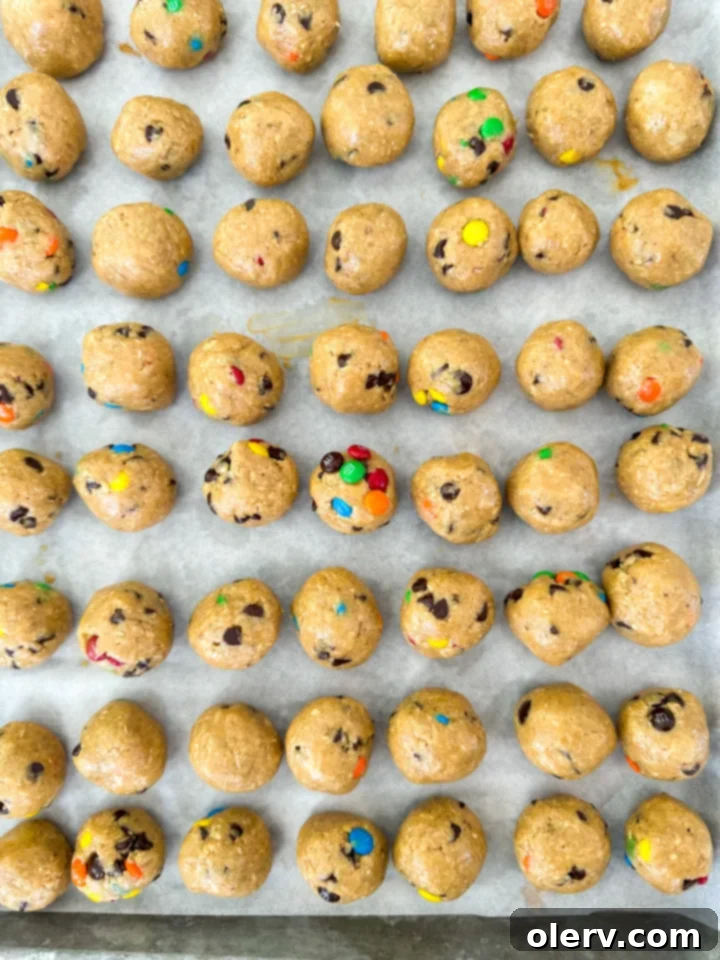 Satisfying Monster Cookie Protein Bites 2 Monster Cookie Protein Bites scattered on a white surface