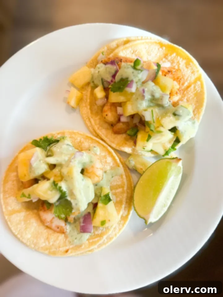 Crispy Air Fryer Shrimp Tacos 2 Delicious air fryer shrimp tacos with fresh pineapple salsa on a cutting board, ready to be served