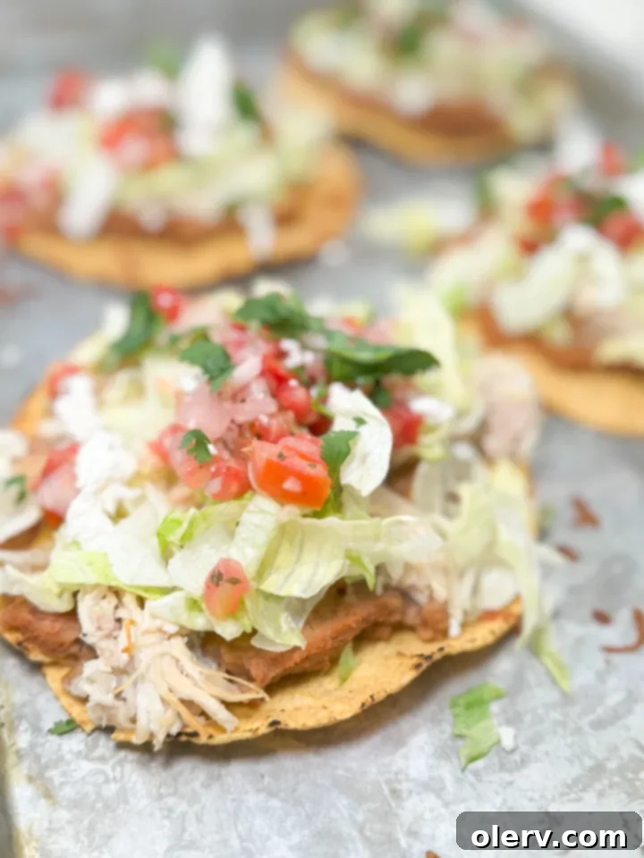 Crispy Chicken Tostadas 2 Delicious chicken tostadas piled high with fresh toppings, ready to eat.