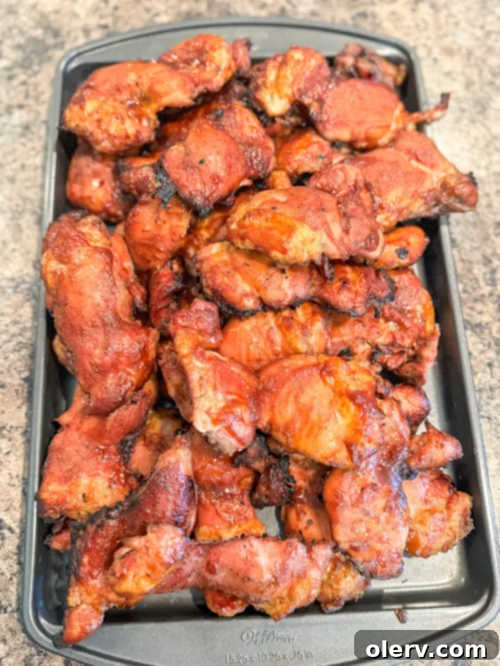 Slow-Smoked BBQ Perfection 6 smoked BBQ chicken thighs with charred sauce