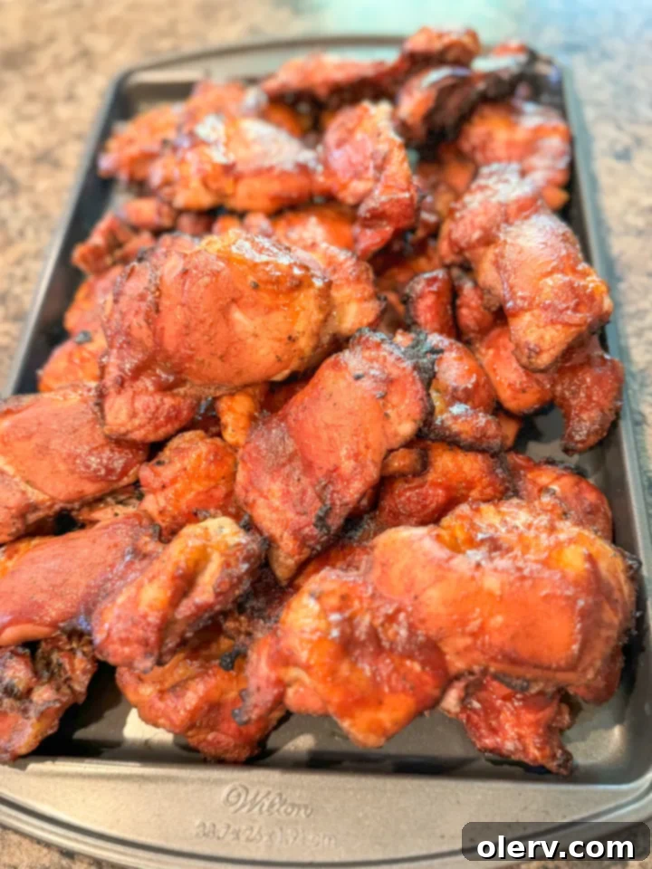 Slow-Smoked BBQ Perfection 7 smoked BBQ chicken thighs served with extra sauce