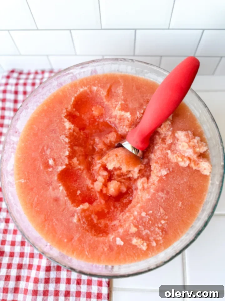 Summer Chill Sip 3 Close-up view of the vibrant red frozen summer slush base in a clear container, ready for freezing