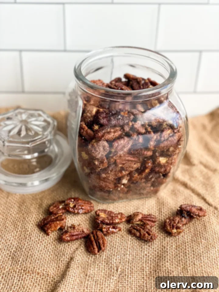 Irresistible Candied Pecans 3 A bowl filled with fresh candied pecans, ready for snacking, with a spoon nearby.