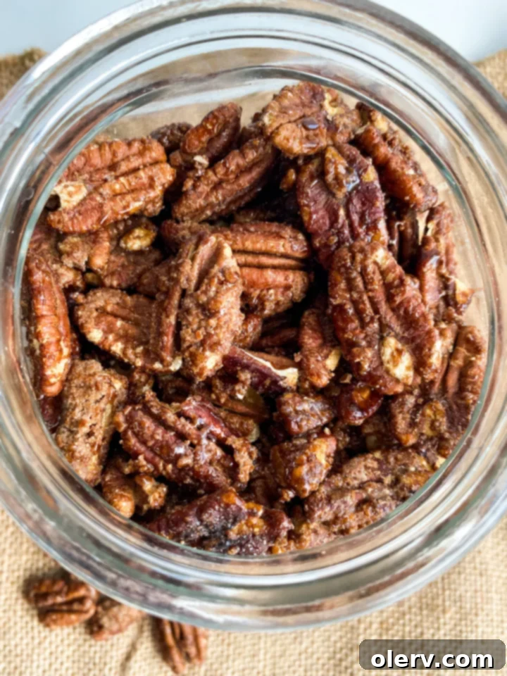 Irresistible Candied Pecans 5 A bowl of candied pecans in the foreground, with more blurred in the background, suggesting a generous batch.