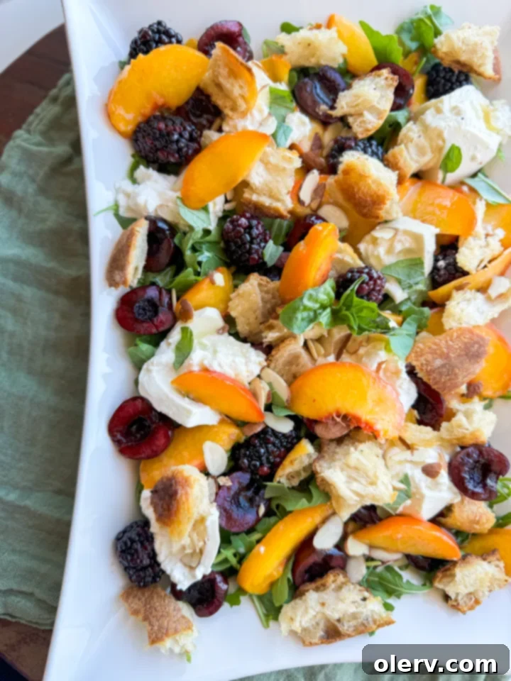 Sun-Kissed Peach & Burrata Delight 3 A close-up of vibrant red cherries, ripe peaches, and dark blackberries, showcasing their fresh appeal as key salad ingredients.