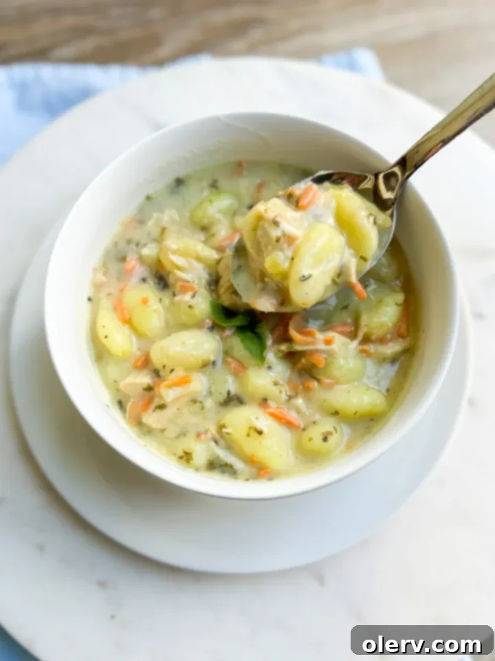 Creamy Chicken Gnocchi Comfort 3 A rustic wooden board displaying fresh ingredients for Chicken Gnocchi Soup, including carrots, celery, onion, garlic, spinach, herbs, gnocchi, and chicken