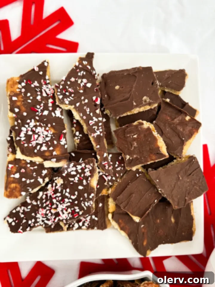 Irresistible Holiday Candy Bark 3 A festive tray of Christmas Crack Candy, some pieces topped with crushed peppermint, others plain, ready to be served.
