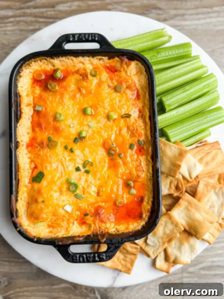 The Ultimate Buffalo Chicken Dip 2 Close-up of a serving of hot Buffalo Chicken Dip with a side of celery and carrot sticks