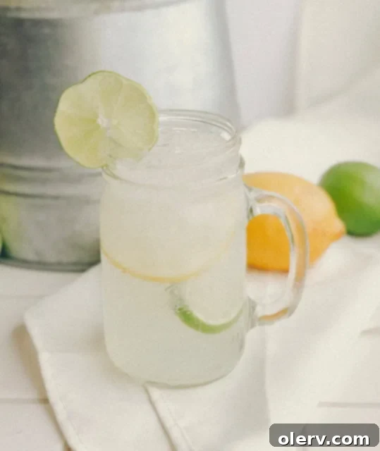 Sun-Kissed Citrus Sparkle 2 Sparkling Citrus Punch in a dispenser with fresh fruit