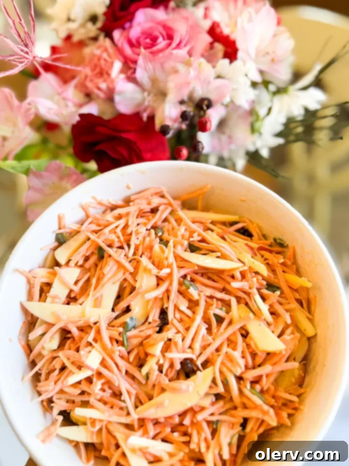 Vibrant Carrot Slaw 5 A serving of Maple Dijon Carrot Slaw Salad in a small bowl, garnished.