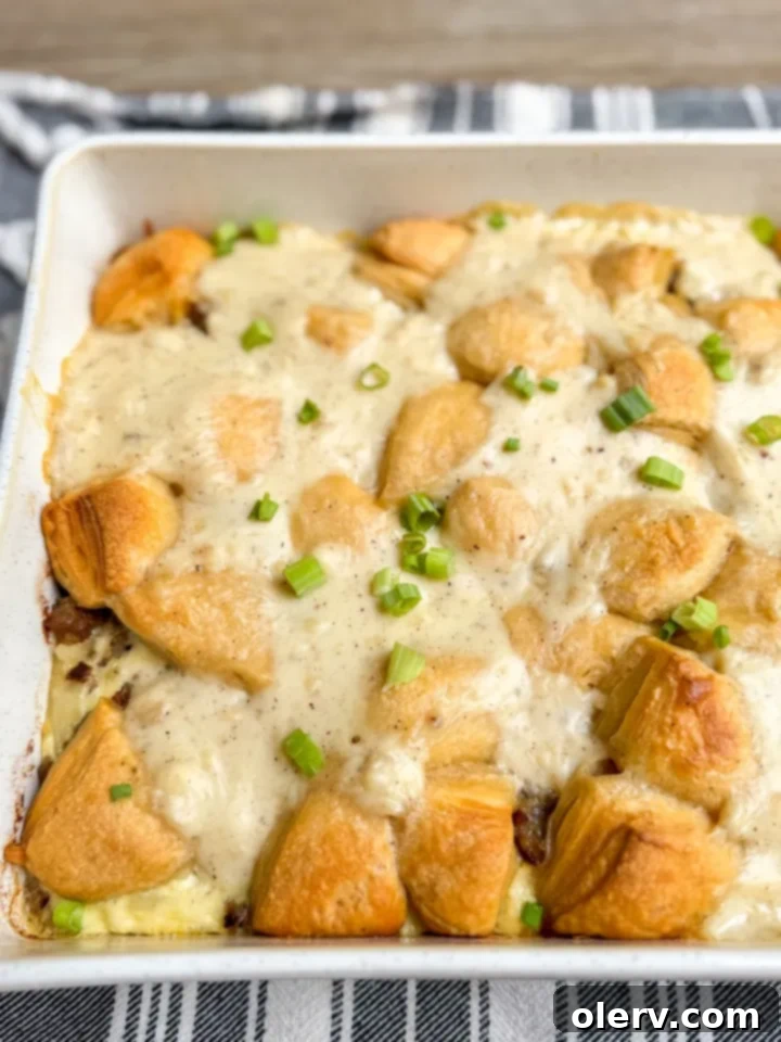 Hearty Biscuits and Gravy Bake 3 Close-up of Biscuits and Gravy Casserole layers before baking, showing hashbrowns, sausage, and cheese.