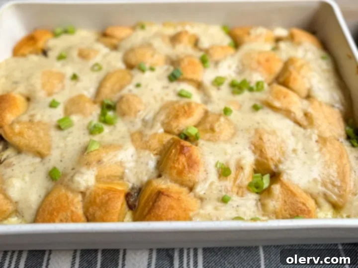 Hearty Biscuits and Gravy Bake 6 Close-up of baked Biscuits and Gravy Casserole, garnished with vibrant green onions, ready to serve.