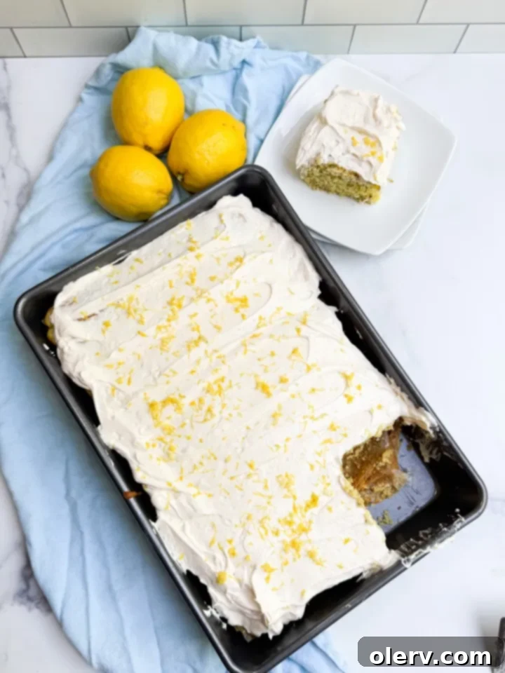 Lemon Dream Bliss 5 Close-up of a slice of Lemon Dream Cake on a plate, garnished with lemon zest