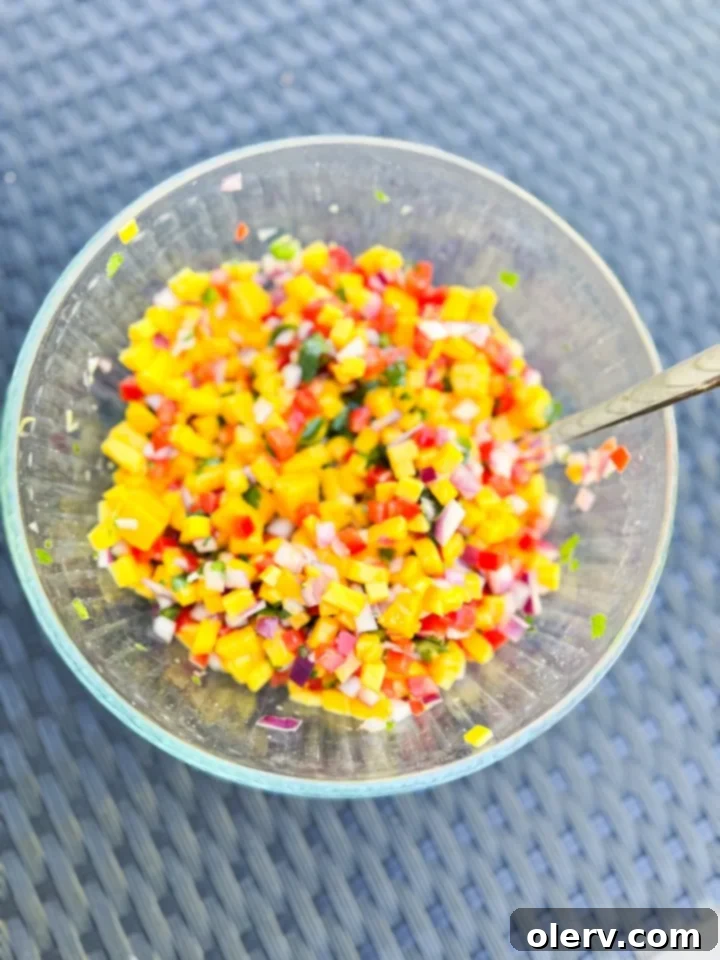Close-up of freshly diced mangoes and other salsa ingredients