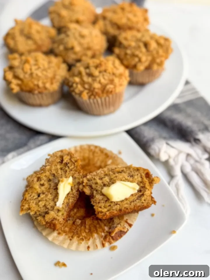 Freshly baked golden-brown banana bread muffins with a generous cinnamon streusel topping, cooling on a wire rack.