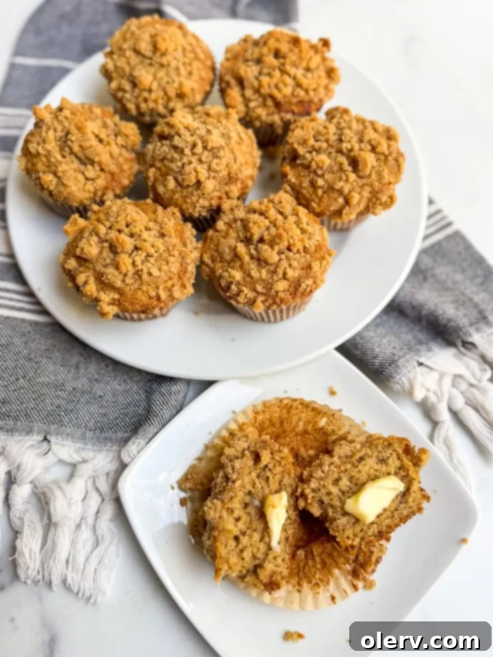 A close-up shot highlighting the golden-brown, crumbly cinnamon streusel topping on a baked banana muffin.