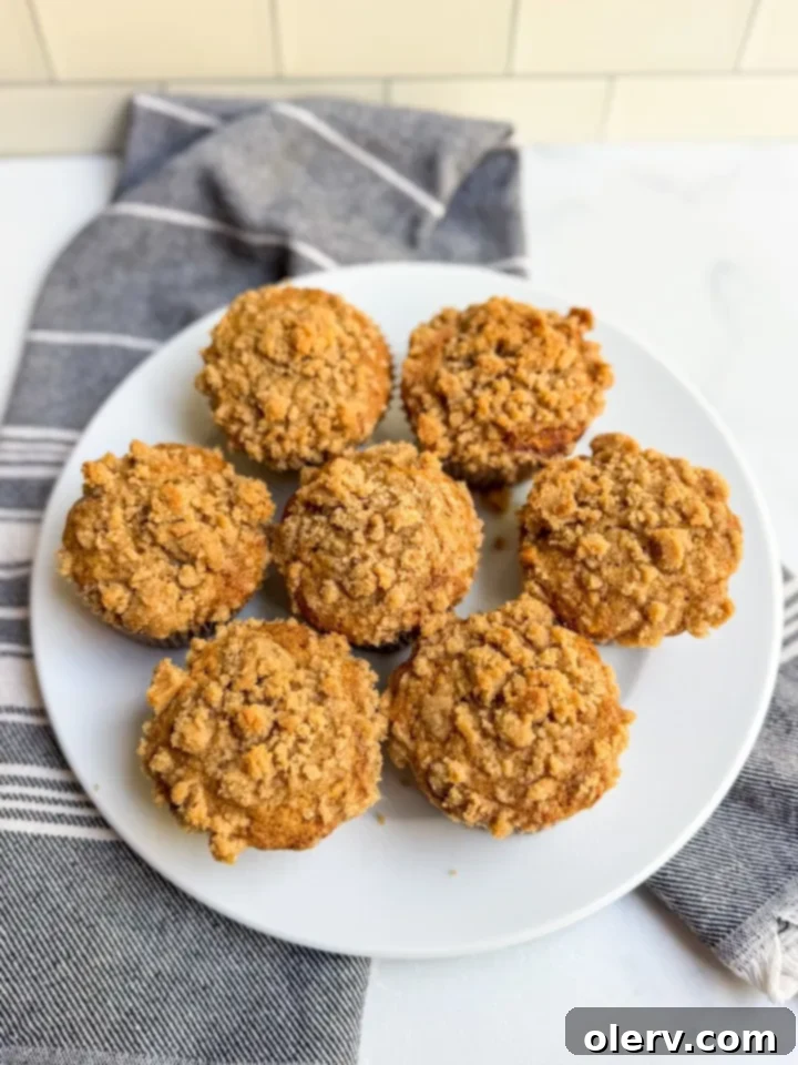 A baking sheet filled with warm, freshly baked banana bread muffins adorned with streusel topping, ready to be devoured.