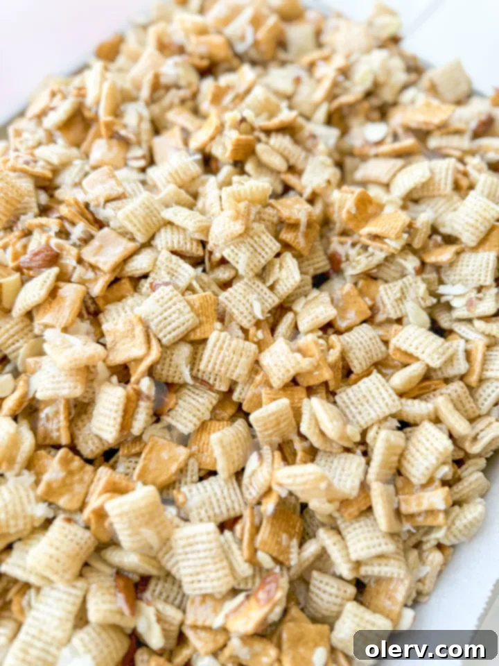 Gems 3 A hand scooping a serving of 'The Good Stuff' sweet Chex mix from a large bowl.