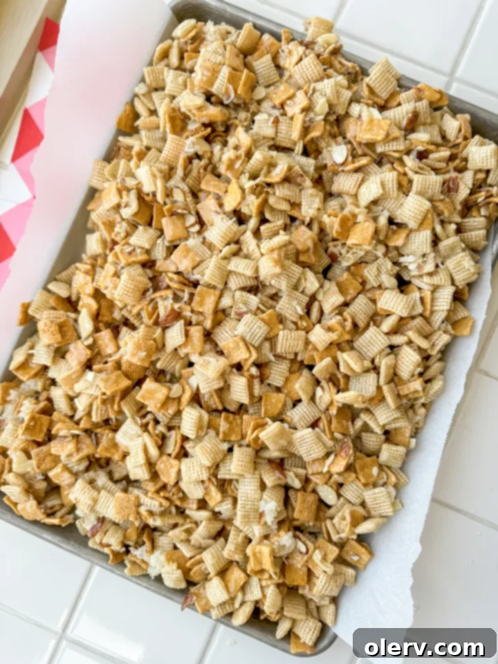 Gems 4 Overhead shot of freshly made 'The Good Stuff' sweet Chex mix spread out on a baking sheet to cool.