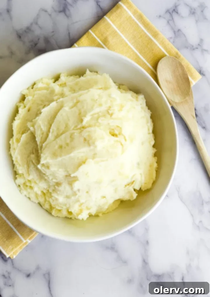 Fluffy Instant Pot Mashed Potatoes in Minutes 3 Close-up of fluffy Instant Pot Mashed Potatoes, garnished with fresh herbs.