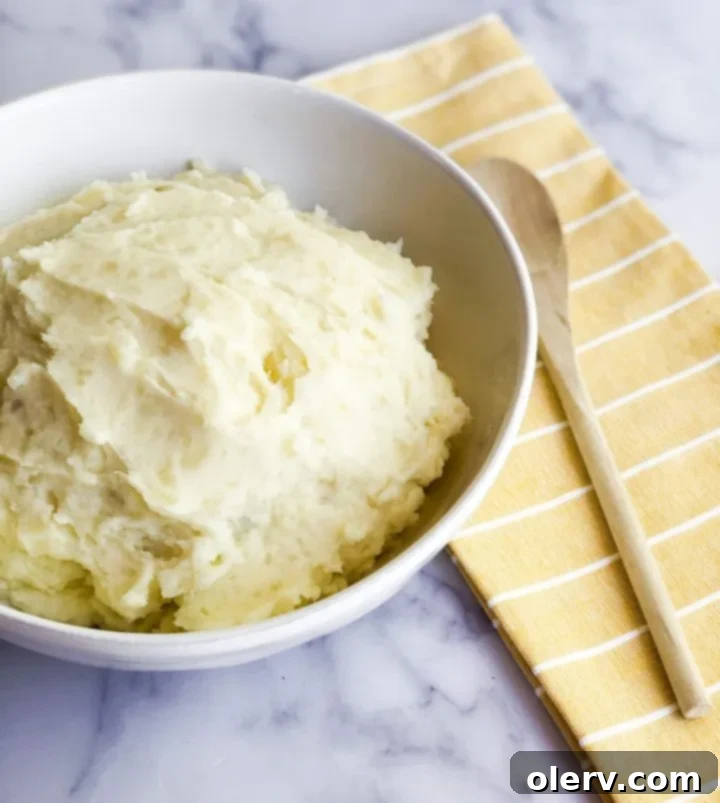 Fluffy Instant Pot Mashed Potatoes in Minutes 4 Scoop of creamy Instant Pot Mashed Potatoes on a spoon.