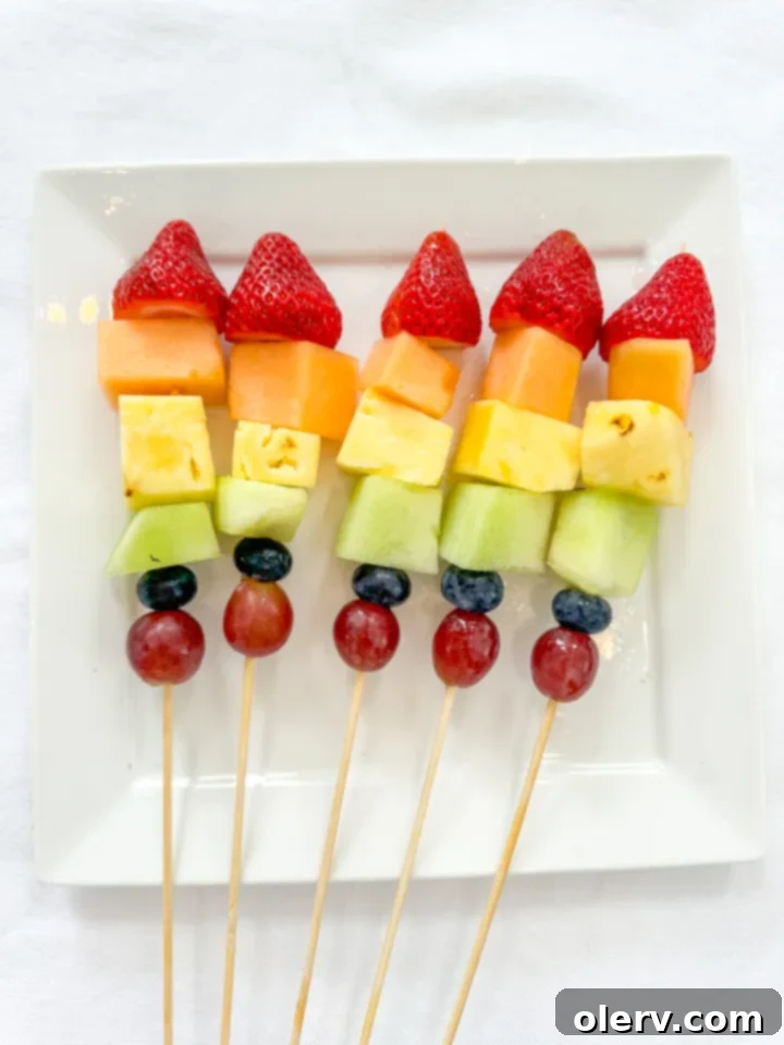 Delicious and colorful summer fruit kabobs on a serving platter