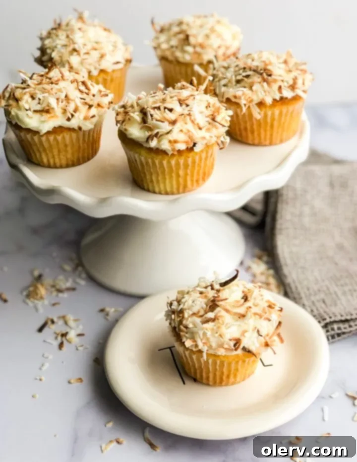 Triple Coconut Dream Cupcakes 6 Stack of coconut cupcakes, showcasing the frosting and toasted flakes