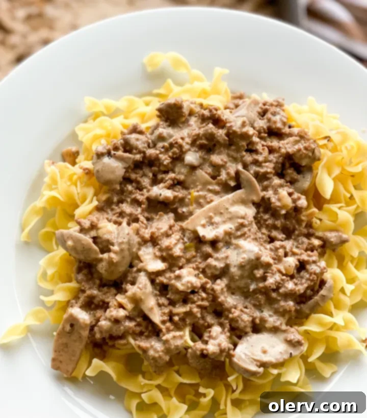 The Ultimate Creamy Beef & Mushroom Stroganoff 8 Chopped garlic, onions, and ground meat browning in a pan for stroganoff preparation