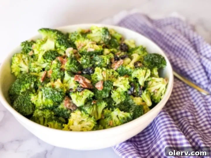 Simple and Delicious Broccoli Salad 6 The creamy, homemade dressing being drizzled over the broccoli salad ingredients, ready to be mixed.