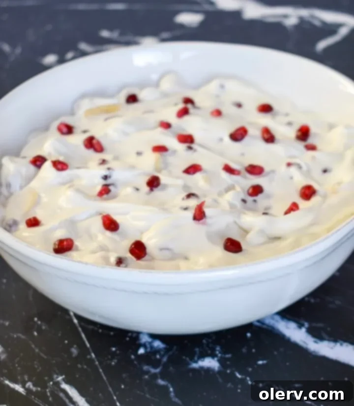 Pomegranate Banana Delight 6 Pomegranate Banana Fruit Salad in a white bowl with a spoon