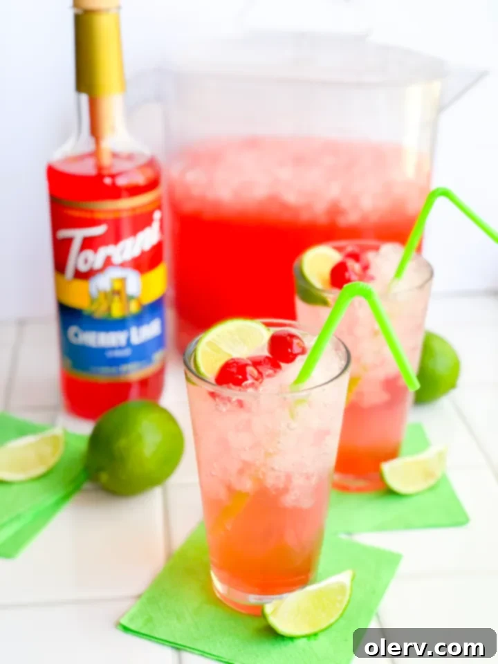 Sparkling Cherry Limeade in a glass with a lime wedge garnish