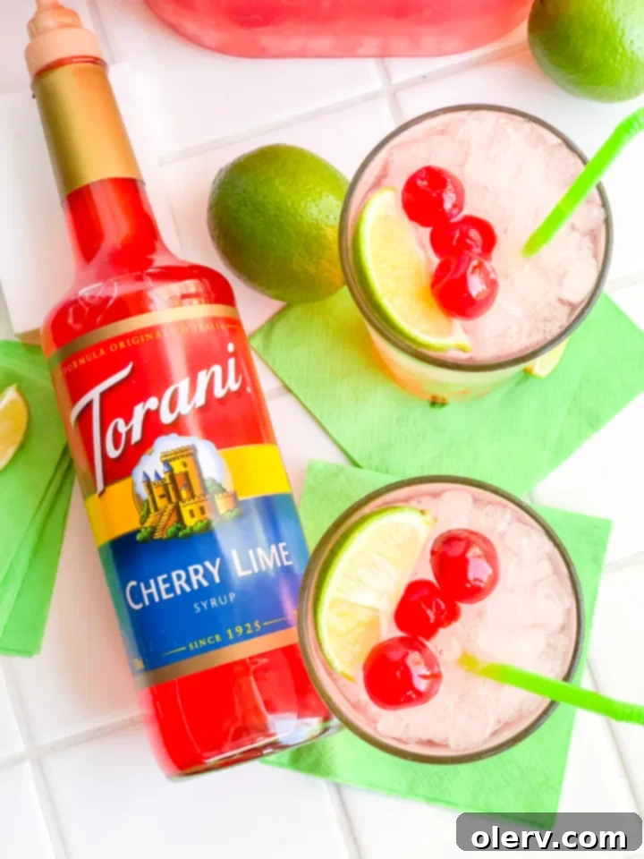 Crimson Zest Sparkle 5 Glass of Sparkling Cherry Limeade with ice, lime wedges, and maraschino cherries