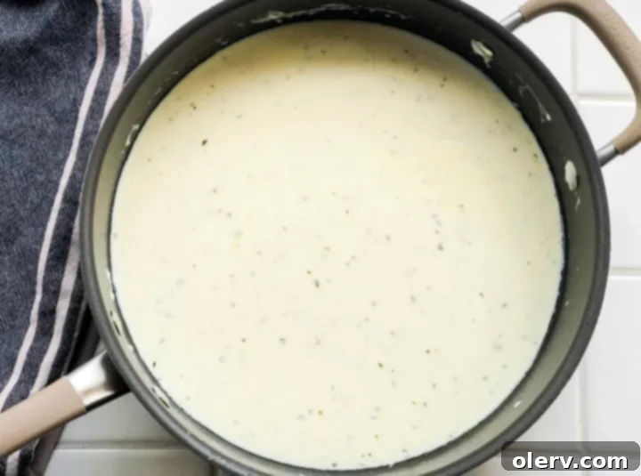 Easy 5-Minute Alfredo Sauce 4 Alfredo sauce simmering in a saucepan