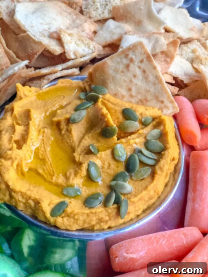 A generous bowl of Savory Pumpkin Hummus, perfectly smooth and garnished, ready for dipping