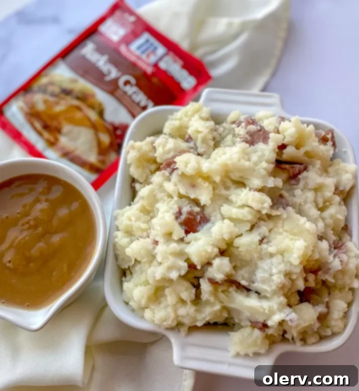 Instant Pot Holiday Magic 7 A serving of creamy mashed potatoes with rich gravy in a white bowl.