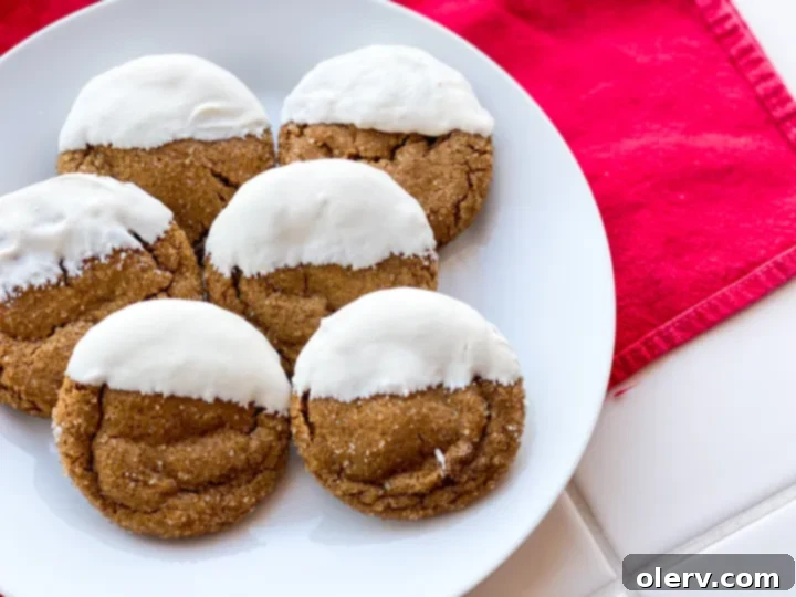 Perfectly Soft and Chewy Gingersnaps 7 Set white chocolate dipped gingersnap cookies on parchment paper