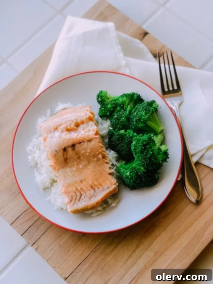 Golden Honey Garlic Glazed Salmon 3 Two pieces of oven-baked honey garlic salmon resting on a wooden cutting board
