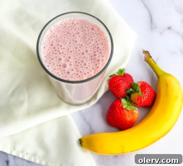 Strawberry Banana Bliss 3 Ingredients for a strawberry banana smoothie laid out: frozen strawberries, banana, Greek yogurt, and protein powder.
