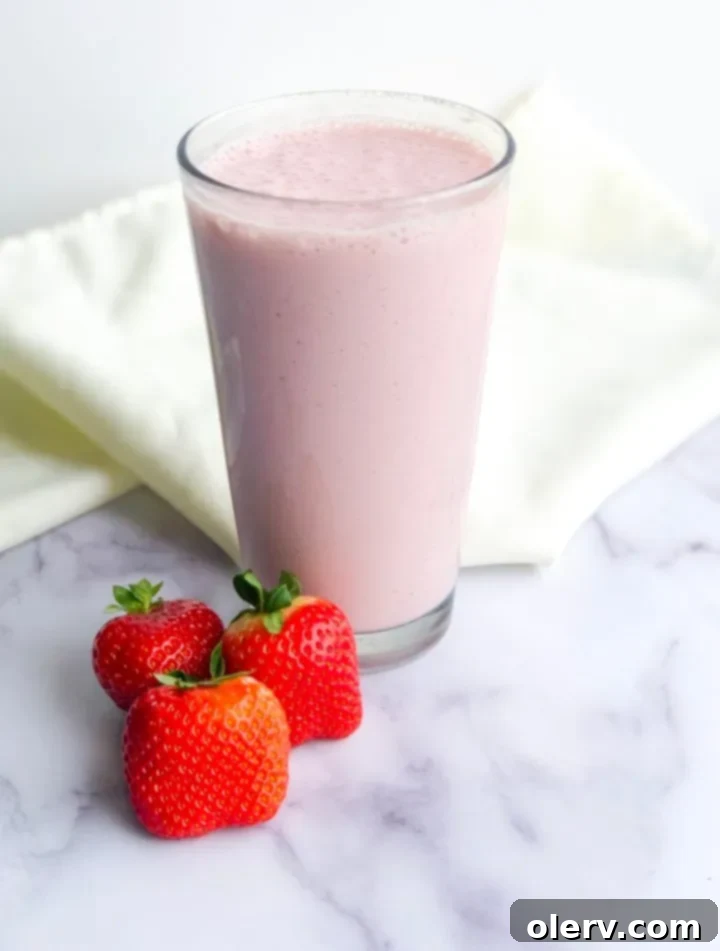 Strawberry Banana Bliss 4 Close-up of frozen strawberries being added to a blender.