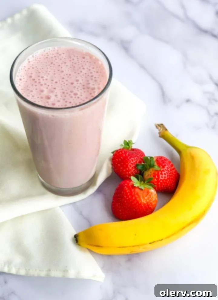 Strawberry Banana Bliss 6 A blender filled with a smooth, pink strawberry banana protein smoothie.