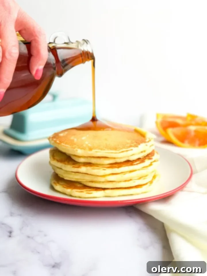 Effortless Overnight Sourdough Pancakes 2 Stack of fluffy sourdough pancakes topped with fresh berries and syrup