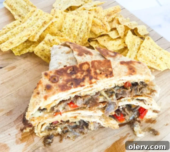 Philly Cheesesteak Crunchwrap 3 Fresh ingredients for a homemade Philly Cheesesteak Crunch Wrap including lavash bread, shaved steak, cheese, bell peppers, and onions