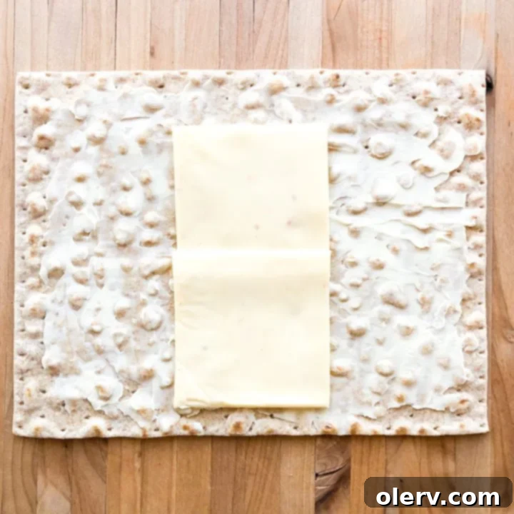 Philly Cheesesteak Crunchwrap 5 A lavash wrap laid flat on a surface with a Laughing Cow cheese wedge spread evenly across it, forming the base for the Philly Cheesesteak Crunch Wrap