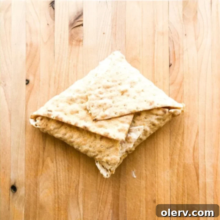 Philly Cheesesteak Crunchwrap 7 A Philly Cheesesteak Crunch Wrap being expertly folded from the corners towards the center, creating a neat, sealed pocket