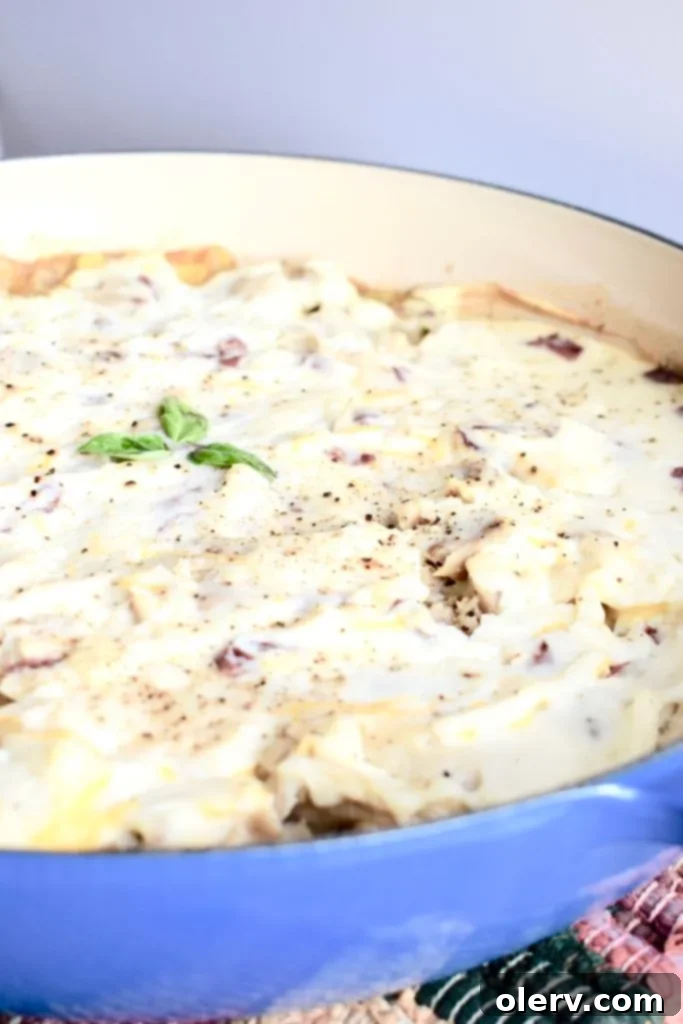 Creamy Chicken & Potato Bake 6 A high-quality Le Creuset cast iron braiser filled with the baked Chicken Shepherd's Pie, showcasing its golden mashed potato crust and vibrant filling.
