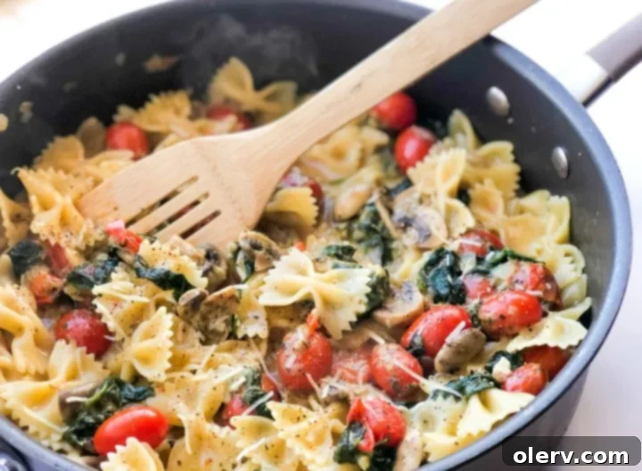 Delicious Meatless Mushroom Spinach Pasta 2 Close-up of a vibrant bowl of mushroom spinach pasta garnished with fresh herbs and parmesan cheese