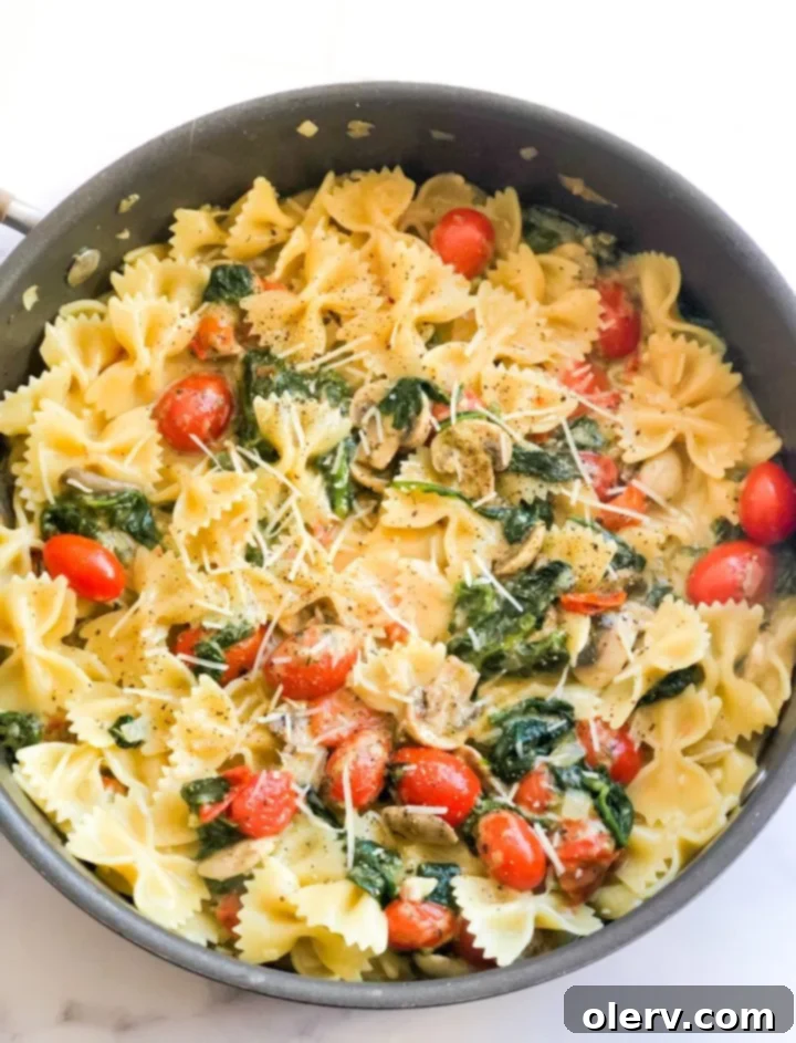 Delicious Meatless Mushroom Spinach Pasta 5 A beautifully arranged serving of mushroom spinach pasta on a white plate, ready to be enjoyed