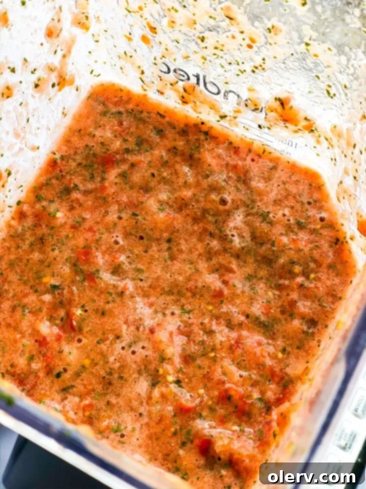 Effortless Blender Salsa 5 A high-powered blender, filled with the colorful ingredients for homemade salsa, ready to be pulsed into a delicious condiment